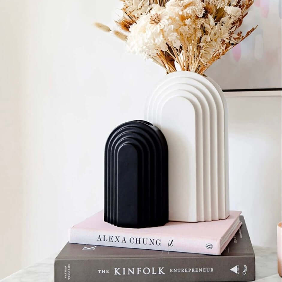 Decorative bookends and vase on books with a neutral background
