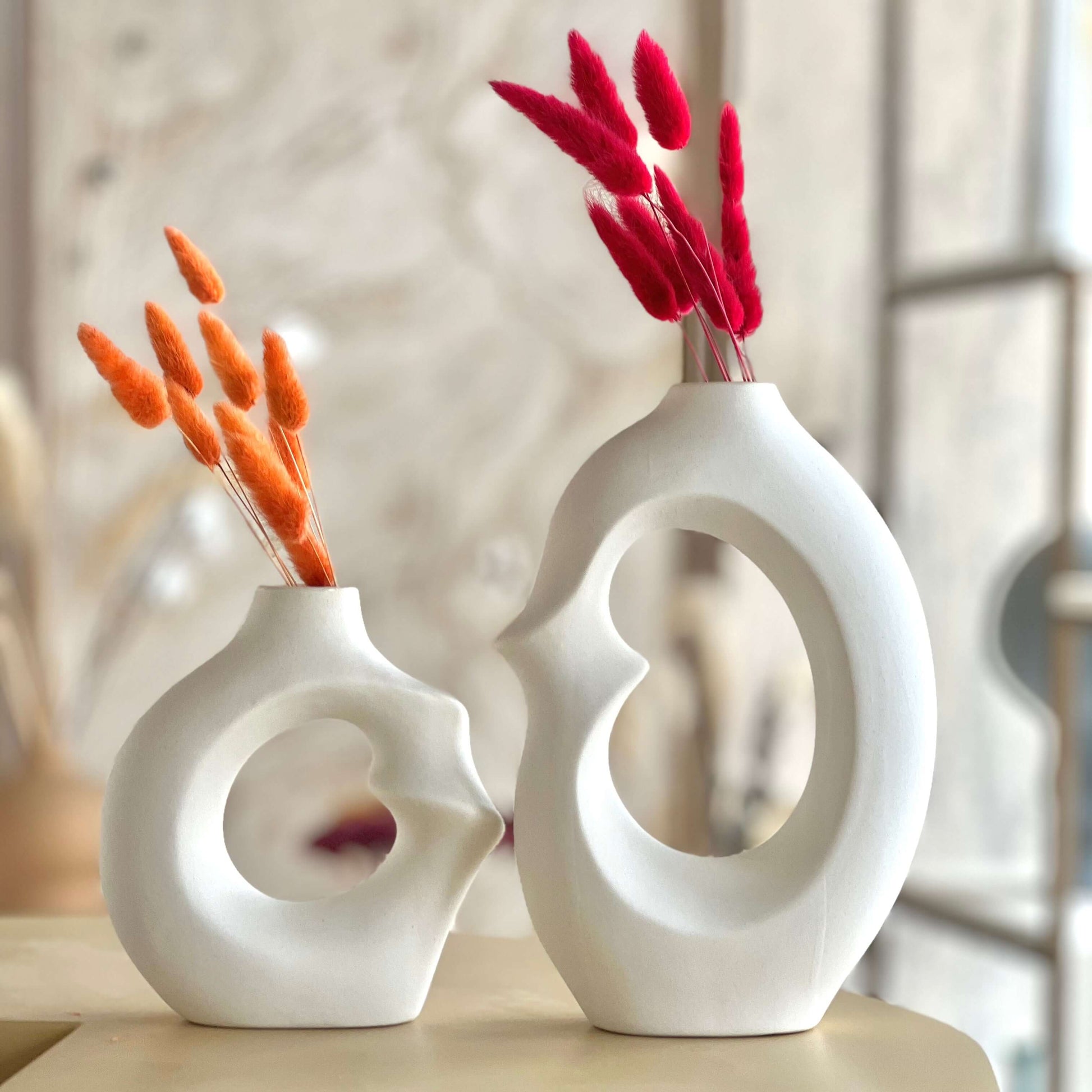 Modern Embrace Ceramic Vase Set showcasing abstract sculptures with dried flowers in a soft matte white finish.