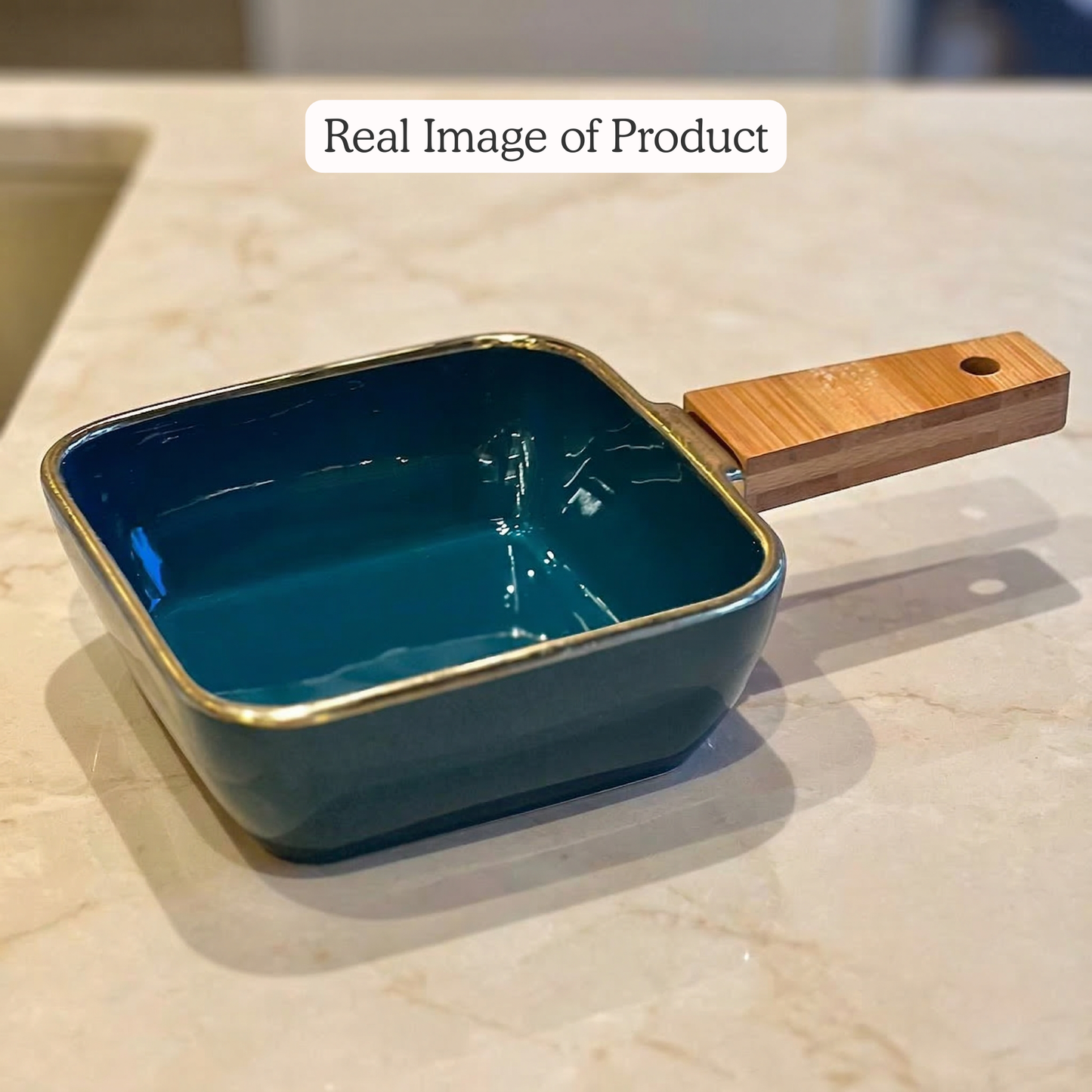 Blue ceramic dish with wooden handle on a light-colored surface