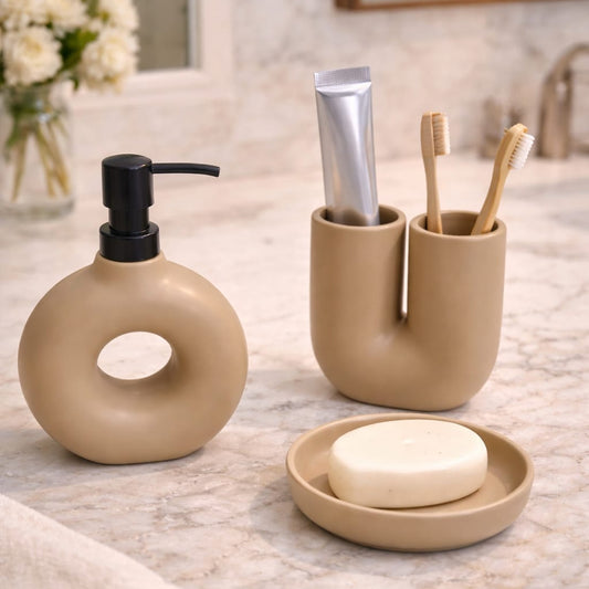 Bathroom counter with beige ceramic accessories including a soap dispenser, toothbrush holder, and soap dish.